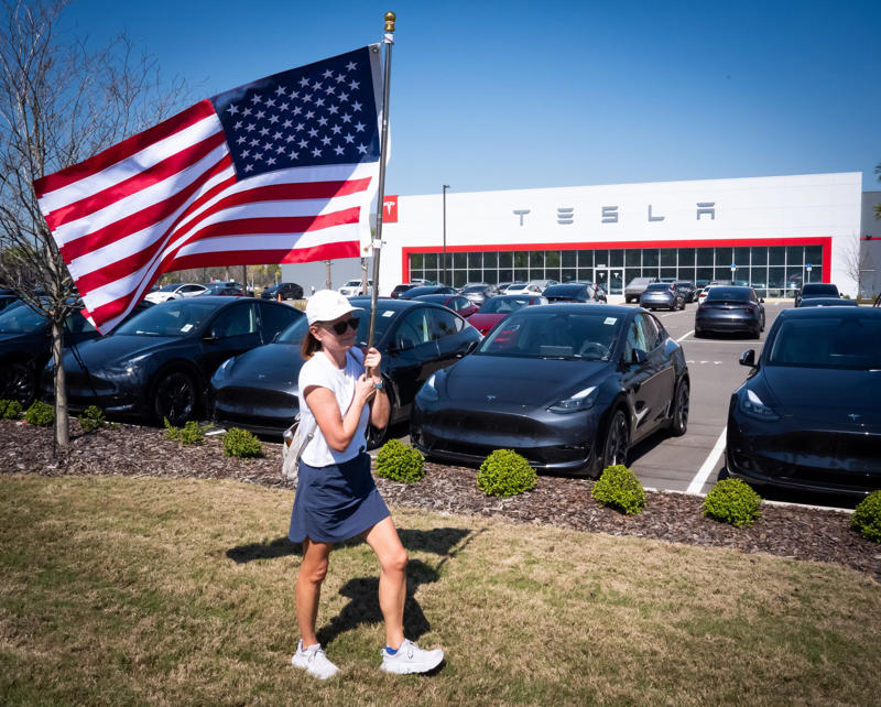 Protester with an American flag against Musk