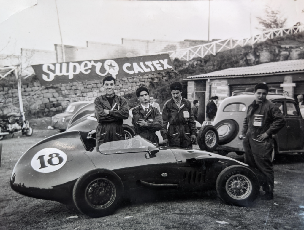 13. Some car mechanics holding it down steady out in Rome, Italy in 1959.