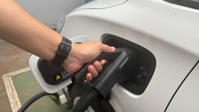 Ilustrasi charger SPKLU tersangkut di mobil listrik